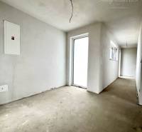 A hallway in a family house with unfinished walls and bare floor.