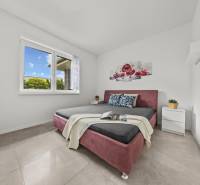 Bedroom in a family house with a double bed, a flower painting, and nightstands.