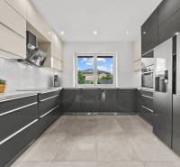 A spacious kitchen in a family house with modern appliances and a view from the window.