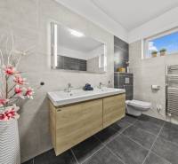 A bathroom with a double sink and floral decoration in a family house.