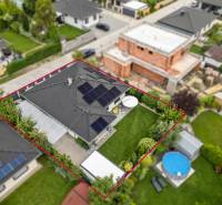 A family house on Feniklová Street in Malinovo, with photovoltaic panels and a garden.