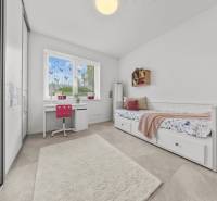 A children's room in a family house with a desk, bed, and wardrobe.