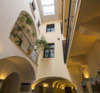 The interior of an office with a glass ceiling, balconies, and plants.