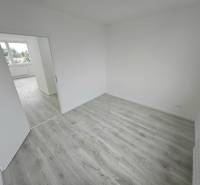 A bright room in a 3-room apartment with laminate flooring and open doors.