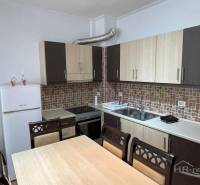 Kitchen in the Holiday Apartment with a dining table and white appliances.