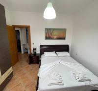 A bedroom in a holiday apartment with a double bed, wardrobes, and a decorative painting on the wall.