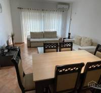 Living room with a dining table and a sofa in a holiday apartment.