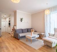 Interior of a family house with a living room, sofa, armchair, and a large refrigerator.