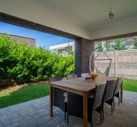 The terrace of a family house on Richtarsko pole in Galanta with rattan furniture and a garden.
