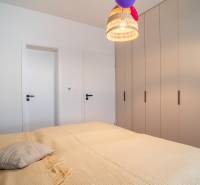 Bedroom in a family house with a large bed, wardrobe, and pendant light.
