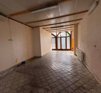 Empty commercial spaces with tiled floors and glass doors.