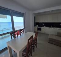 A kitchen and dining table in a holiday apartment with a sea view.