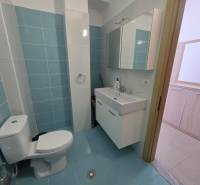Bathroom with light blue tiles in a Holiday Apartment, sink and mirror cabinet.