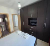 Bedroom in a holiday apartment with a large wardrobe and an en-suite bathroom.