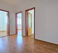 A corridor with light laminate and three open doors in a 3-room apartment.