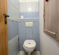 A bathroom with light blue tiles in a three-room apartment.