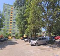 Parking lot in Bratislava - Petržalka on Osuského Street with a view of apartment buildings and greenery.