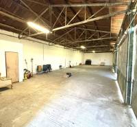 Interior of warehouses and halls with high wooden ceiling and concrete floor.