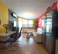 The living room with a dining area in the 2-room apartment has yellow and red walls, a sofa.