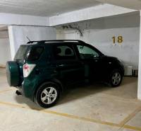 The car is parked in the garage at parking spot number 18.