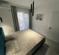 Recreational apartment with a comfortable bed, air conditioning, and balcony doors with a view.