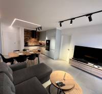 The living room of the holiday apartment is equipped with a kitchen, a dining table, and a comfortable sofa.