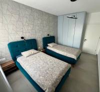 Double room with blue beds and a patterned wall in the Holiday Apartment.