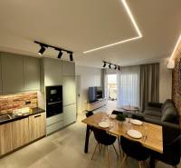 Living room with kitchen in a holiday apartment. Brick wall, dining table, and comfortable sofa.