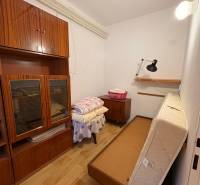 A small room with antique furniture and a fold-out bed in a family house.