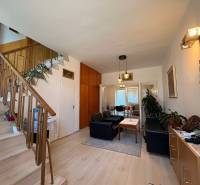 Living room with a staircase in a family house, with seating and decorative elements.