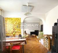 Interior of a family house with colorful wall painting, refrigerator, and fireplace.