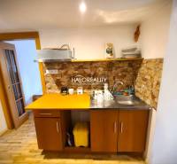 A kitchen in a family house with wooden furniture and stone cladding.