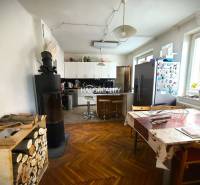 Family house kitchen with a stove, dining table, and refrigerator on a colorful floor.