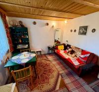 Living room in a cabin with a wooden ceiling, patterned rugs, and comfortable seating.
