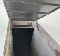 Basement with stairs and an open hatch in a family house.