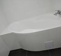 White bathtub with a faucet in the bathroom of a family house.