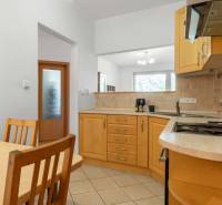 A kitchen in a 2-room apartment with wooden furniture and built-in appliances.
