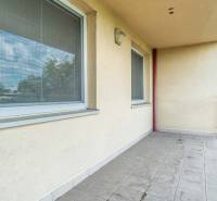 A balcony with tiles and two windows in a 2-room apartment.