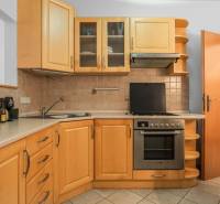 A kitchen with a corner unit, stove, and bar accessories in a 2-room apartment.