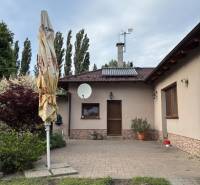 Family house in Malacky, front yard with terrace, greenery, and satellite dish.