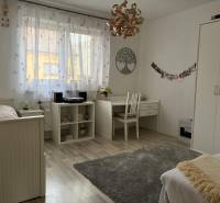 A bright room in a family house with white furniture, a desk, and decorations.