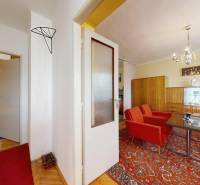 Living room and bedroom in a family house with retro furniture and a red-orange carpet.
