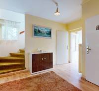 Interior of a family house with carpeted stairs and light furniture.