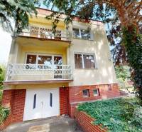 A family house on Božena Němcová Street in Komárno surrounded by trees and climbing greenery.