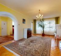 Living room in a family house with a carpet, furniture, and a houseplant.