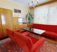 Living room in a family house with red sofas and wooden furniture.