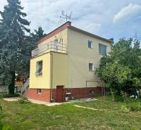 A family house on Božena Němcová Street in Komárno with a surrounding garden and a tree.