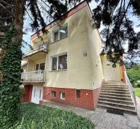 A family house on Božena Němcová Street in Komárno surrounded by greenery and stairs.
