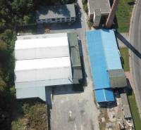 Aerial view of halls and warehouses near Železničná Street, surrounded by greenery and land.