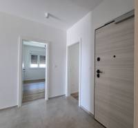 Entrance hallway in a 4-room apartment with wooden doors and tiles.